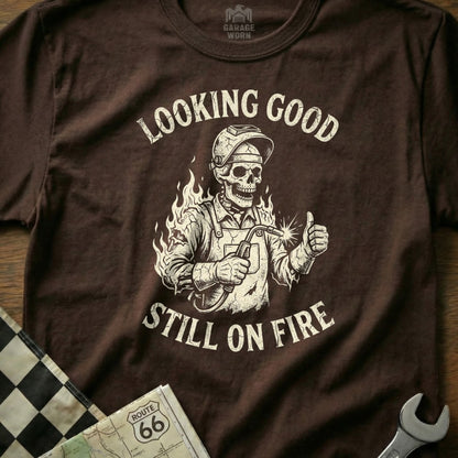 Skeleton welder giving thumbs up with "Looking Good Still On Fire" text.