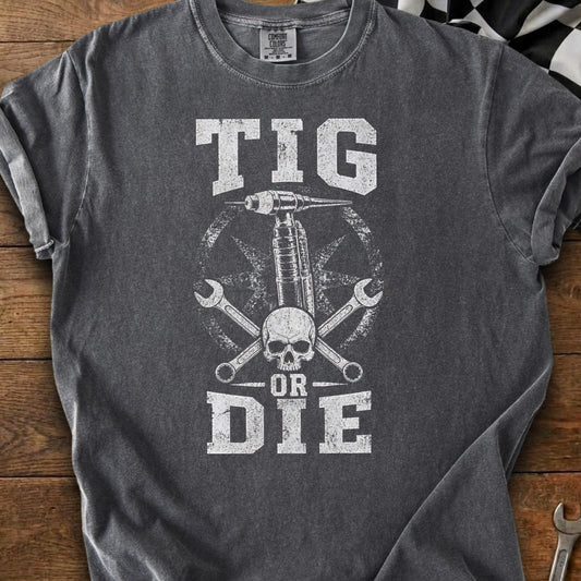 Dark gray t-shirt with distressed graphic of TIG welder, skull, wrenches, and text "TIG OR DIE".