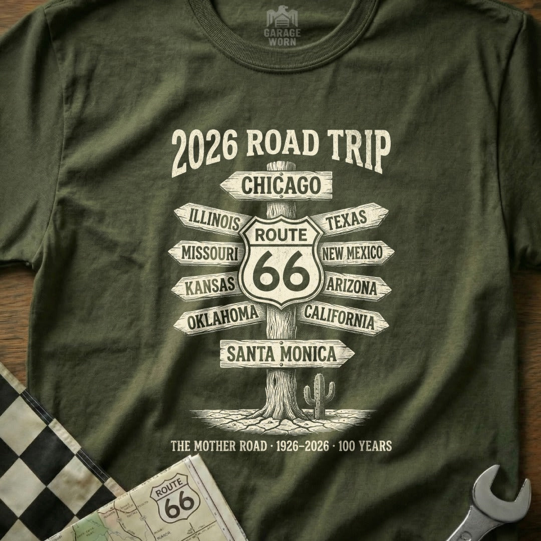 Green t-shirt with "2026 Road Trip Route 66" and directional signs to cities.