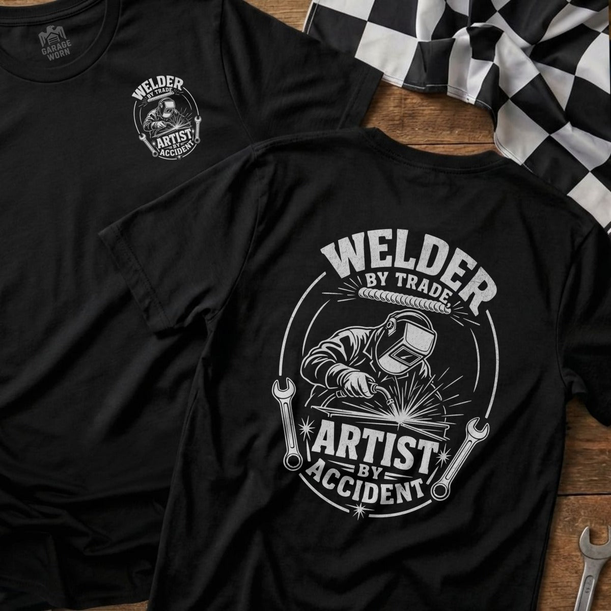 Black t-shirt with "Welder by Trade, Artist by Accident" graphic and welding imagery.