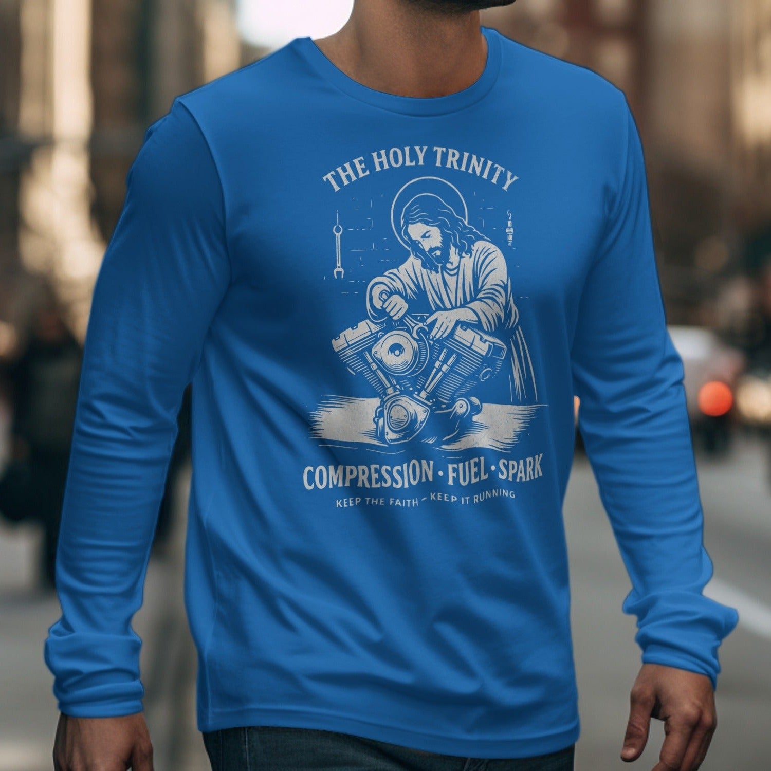 Blue long sleeve shirt with graphic of Jesus working on motorcycle engine.