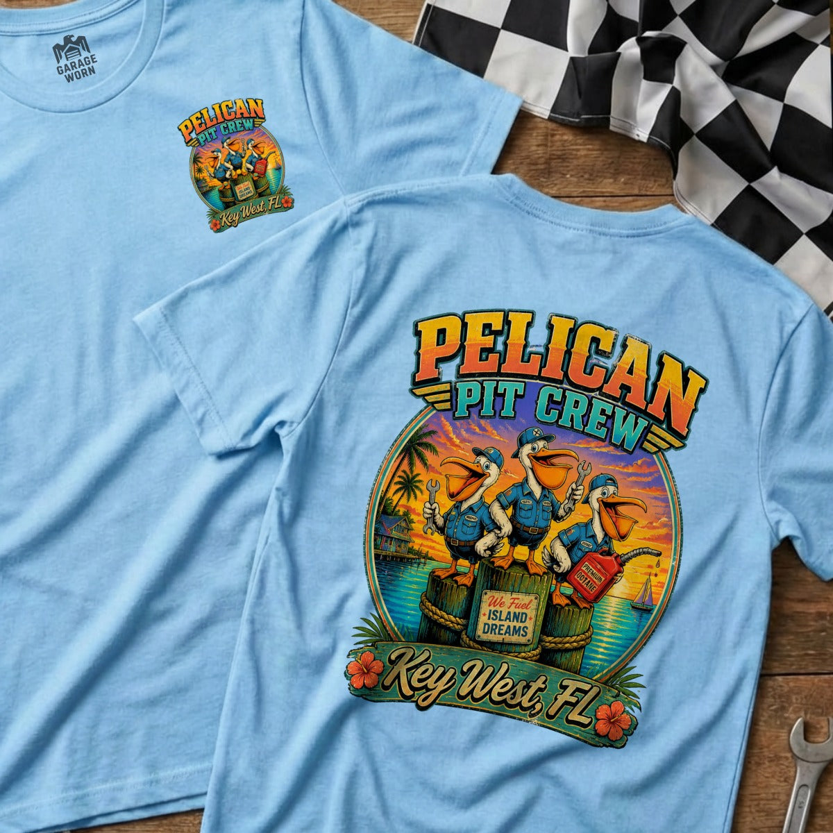 Light blue t-shirt with "Pelican Pit Crew" graphic featuring pelicans with tools and gas can in Key West.