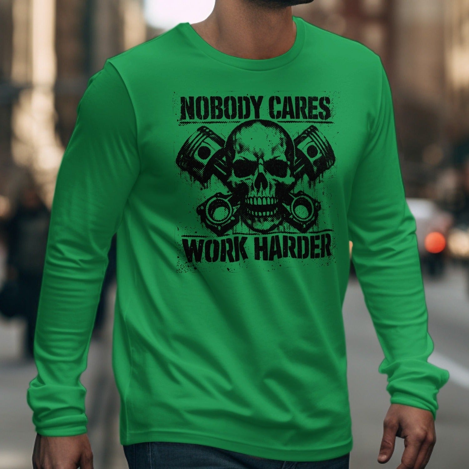 Green long-sleeve shirt with skull, pistons, and text "Nobody Cares Work Harder".