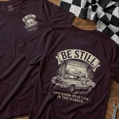 Maroon t-shirt with "BE STILL AND KNOW THAT I AM IN THE GARAGE" and a car graphic.