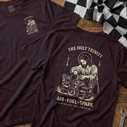 T-shirt graphic of Jesus working on an engine, text "The Holy Trinity Air-Fuel-Spark Keep the Faith - Keep it Running".