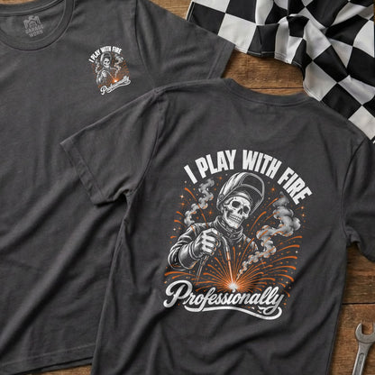 Dark grey t-shirt with a welding skeleton graphic and text "I PLAY WITH FIRE Professionally".
