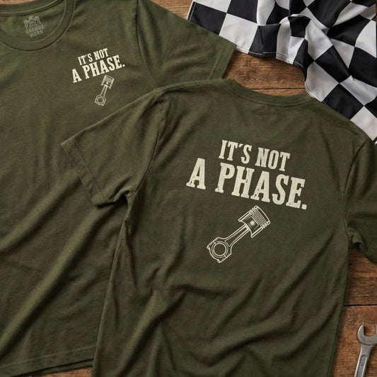 Two olive green t-shirts with a piston graphic and "It's Not A Phase." text.