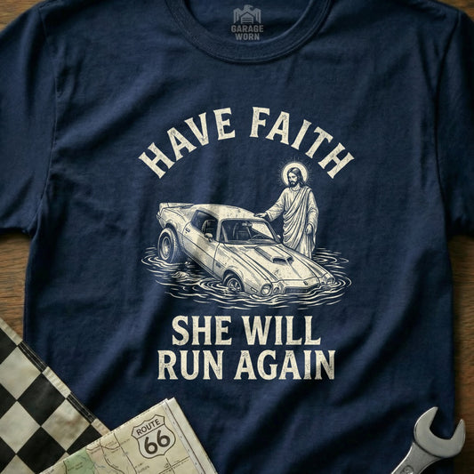 Navy t-shirt with Jesus helping a flooded car, text reads "Have Faith She Will Run Again".