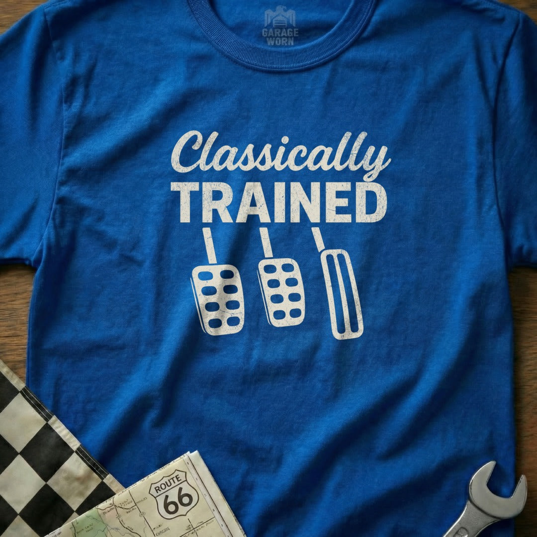 Blue t-shirt with "Classically Trained" and pedal graphics, near checkered flag and map.