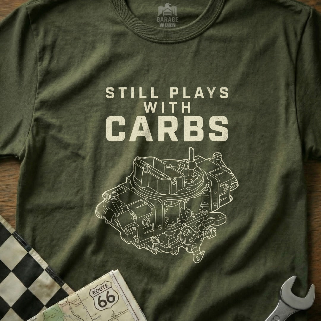 Olive green t-shirt with "Still Plays With Carbs" and a detailed carburetor graphic.