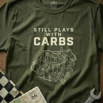 Olive green t-shirt with "Still Plays With Carbs" and a detailed carburetor graphic.