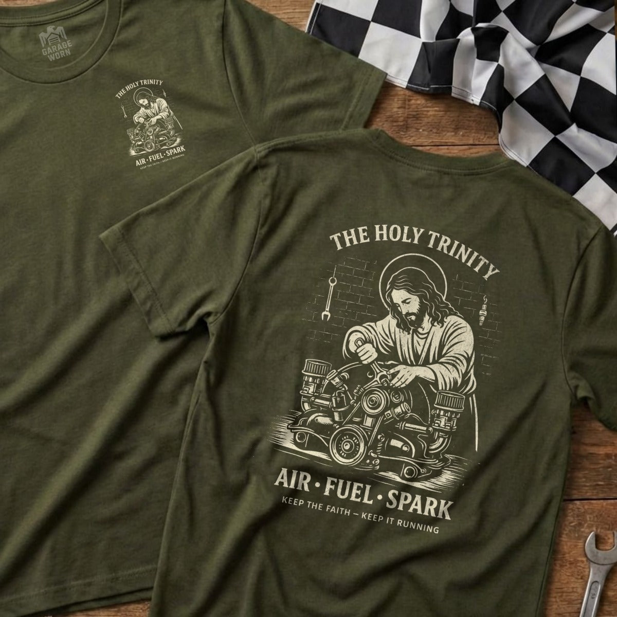 Olive green t-shirts featuring "The Holy Trinity" and "Air-Fuel-Spark" with mechanic Jesus illustration.