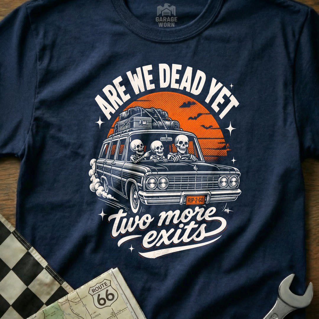 Skeleton family in a car with luggage, text "ARE WE DEAD YET two more exits".
