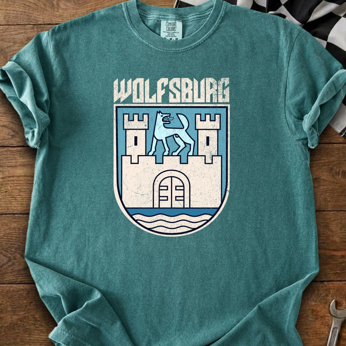 Teal t-shirt with "WOLFSBURG" text and a blue and white coat of arms.