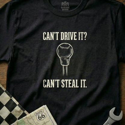 Black t-shirt with text "CAN'T DRIVE IT? CAN'T STEAL IT." and a gear shift knob.