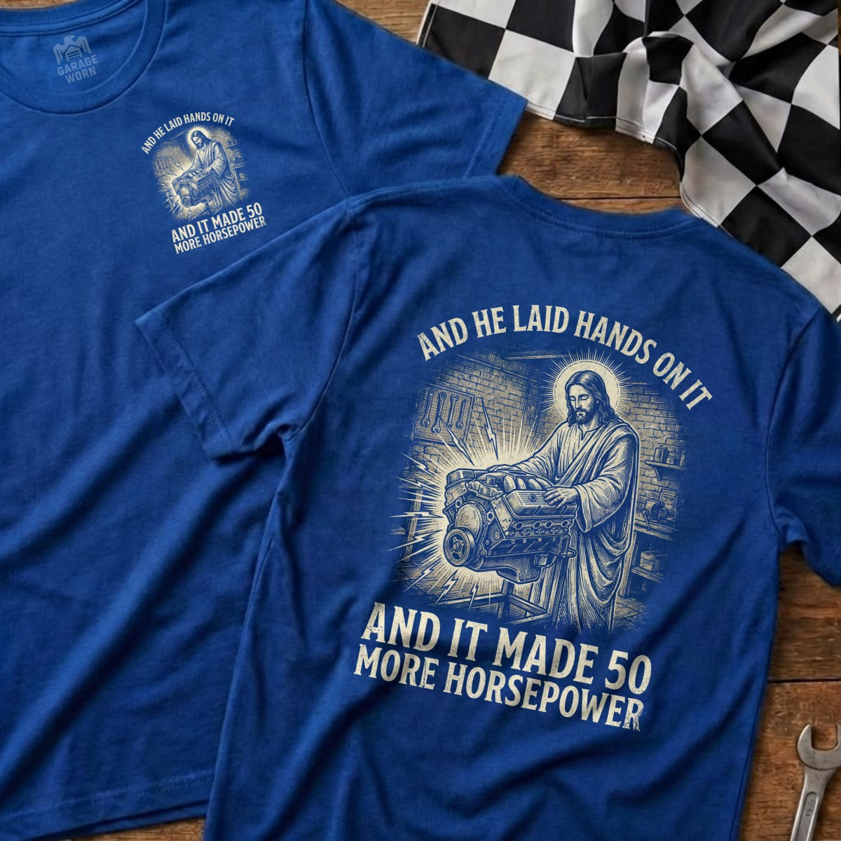 Blue t-shirt with Jesus working on an engine, text: "And He Laid Hands On It And It Made 50 More Horsepower".
