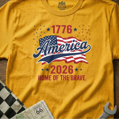 Yellow t-shirt with "1776 America 2026 Home of the Brave" and USA flag.
