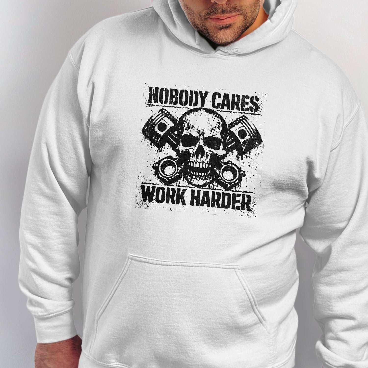 White hoodie with skull, pistons, and text "Nobody Cares Work Harder".