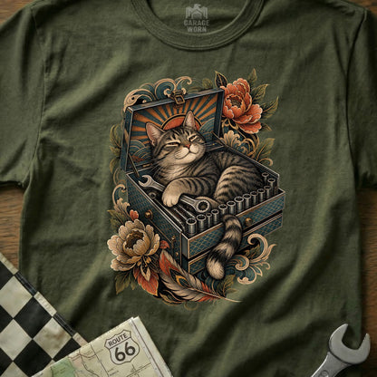 Tabby cat sleeping in an open toolbox with wrenches and flowers.
