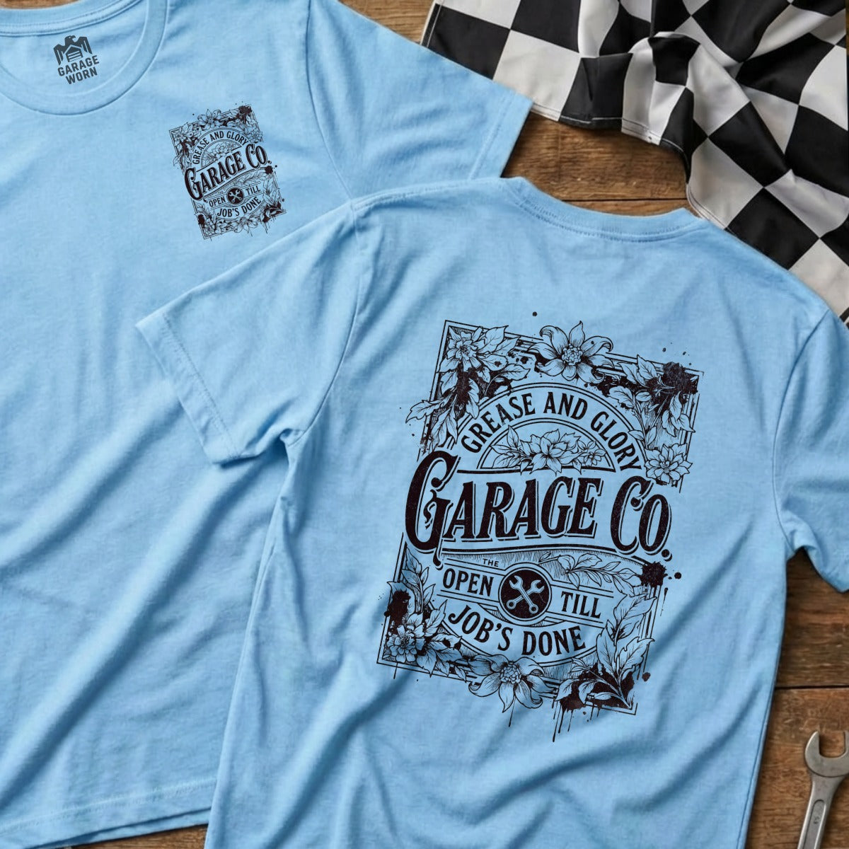 Light blue t-shirt with "Grease and Glory Garage Co." floral graphic and text.