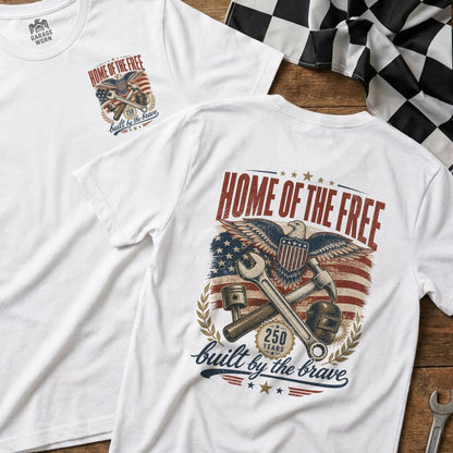 White t-shirt with "HOME OF THE FREE built by the brave" eagle graphic.