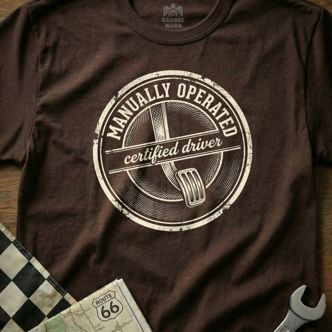 Brown t-shirt with "Manually Operated Certified Driver" circular distressed logo.