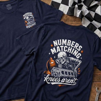 Navy t-shirt with skeleton mechanic examining engine part, text: Numbers Matching Knees Aren't.