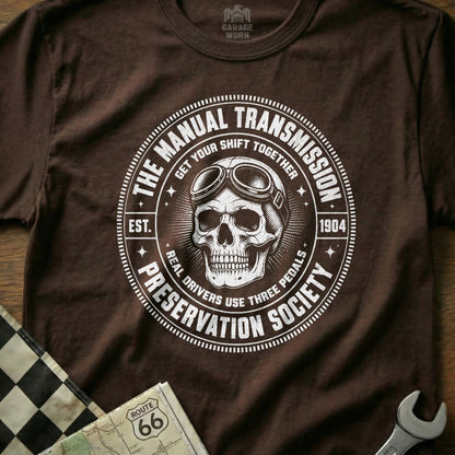 Brown t-shirt featuring a skull with goggles and the text "The Manual Transmission Preservation Society".