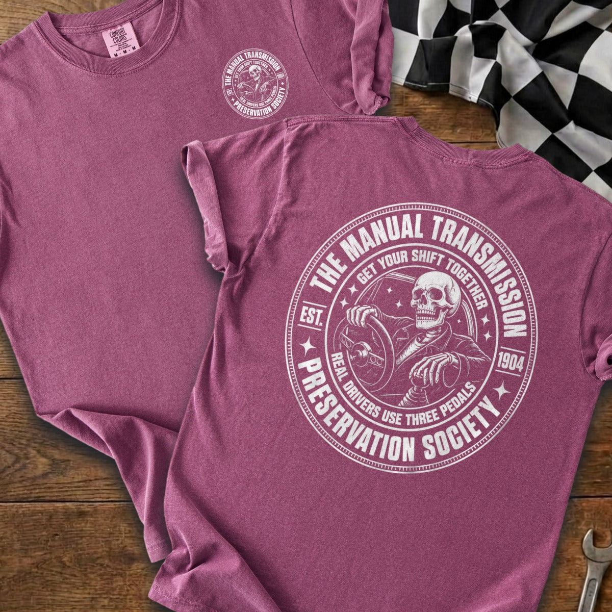 Maroon t-shirt with a skeleton driving a manual transmission graphic and text.