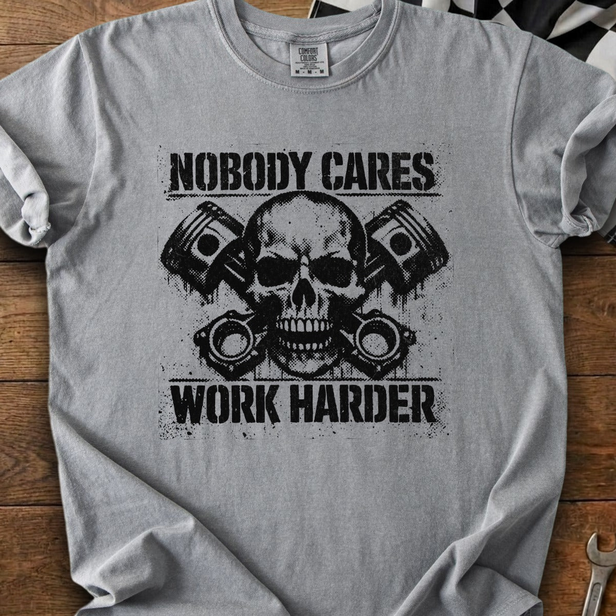 Grey t-shirt with skull, pistons, and "Nobody Cares Work Harder" text.