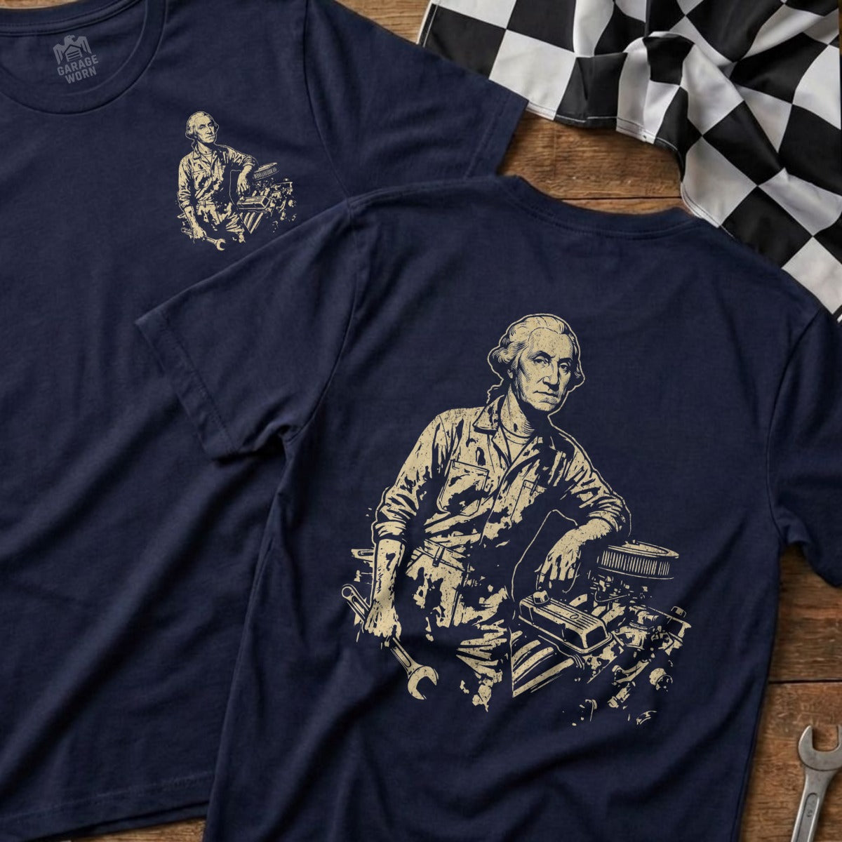 George Washington leaning on car engine with tools on dark blue t-shirt.