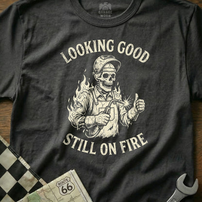 Skull welder giving thumbs up with "Looking Good Still On Fire" text.