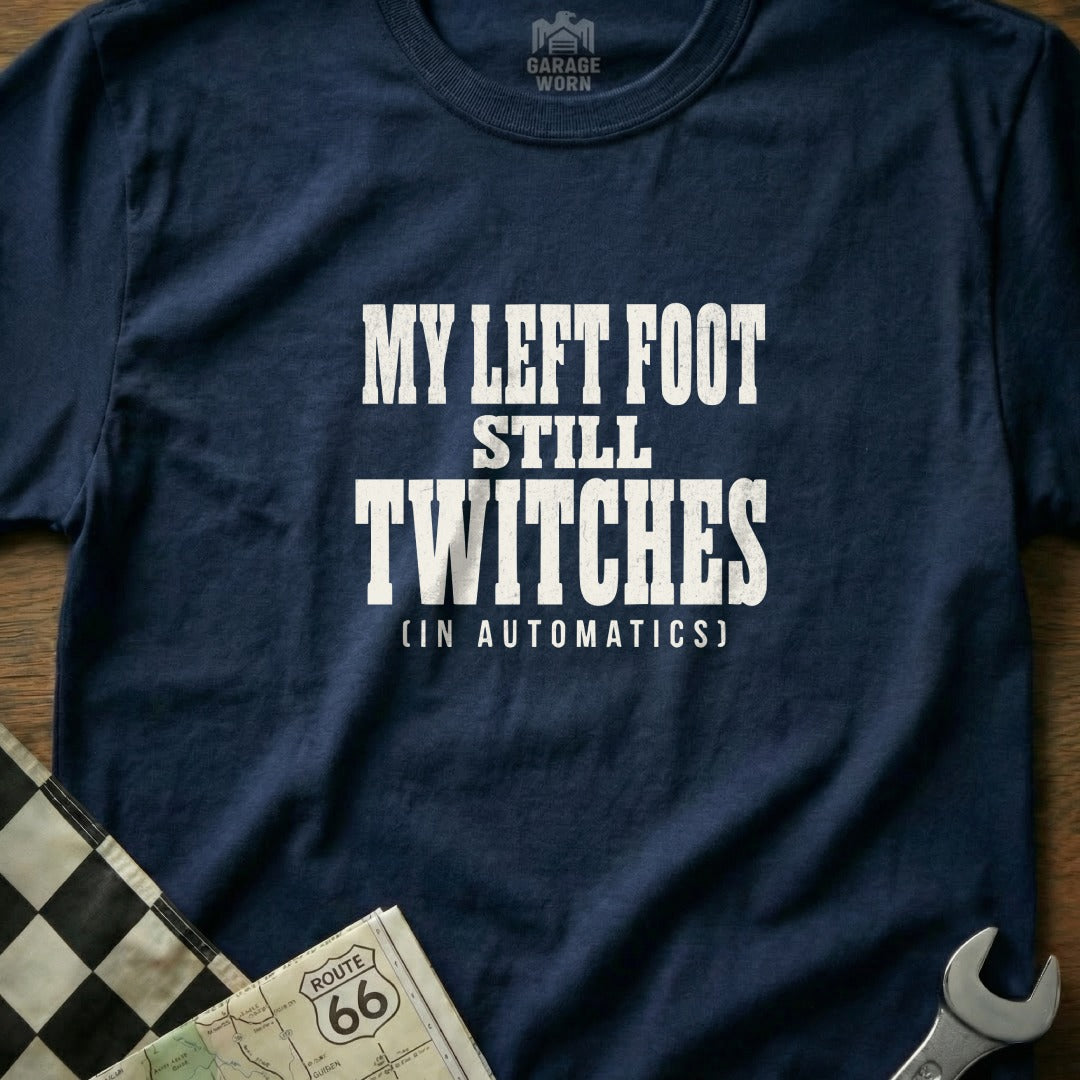 Navy t-shirt with white text "MY LEFT FOOT STILL TWITCHES (IN AUTOMATICS)".