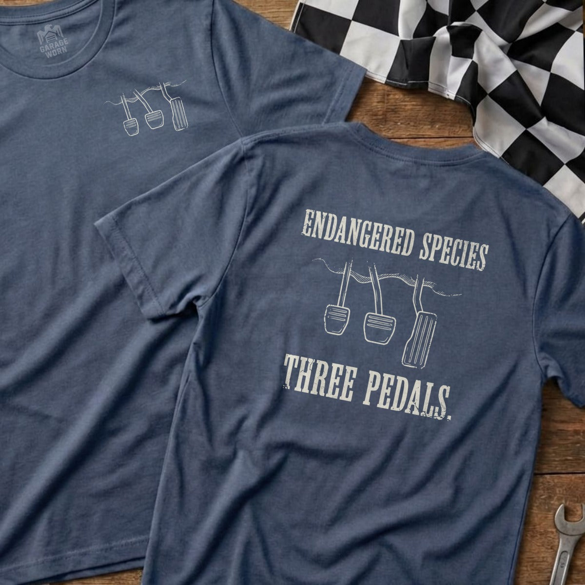 T-shirt with "Endangered Species Three Pedals" graphic and car pedals illustration.