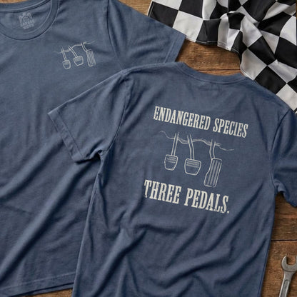 T-shirt with "Endangered Species Three Pedals" graphic and car pedals illustration.