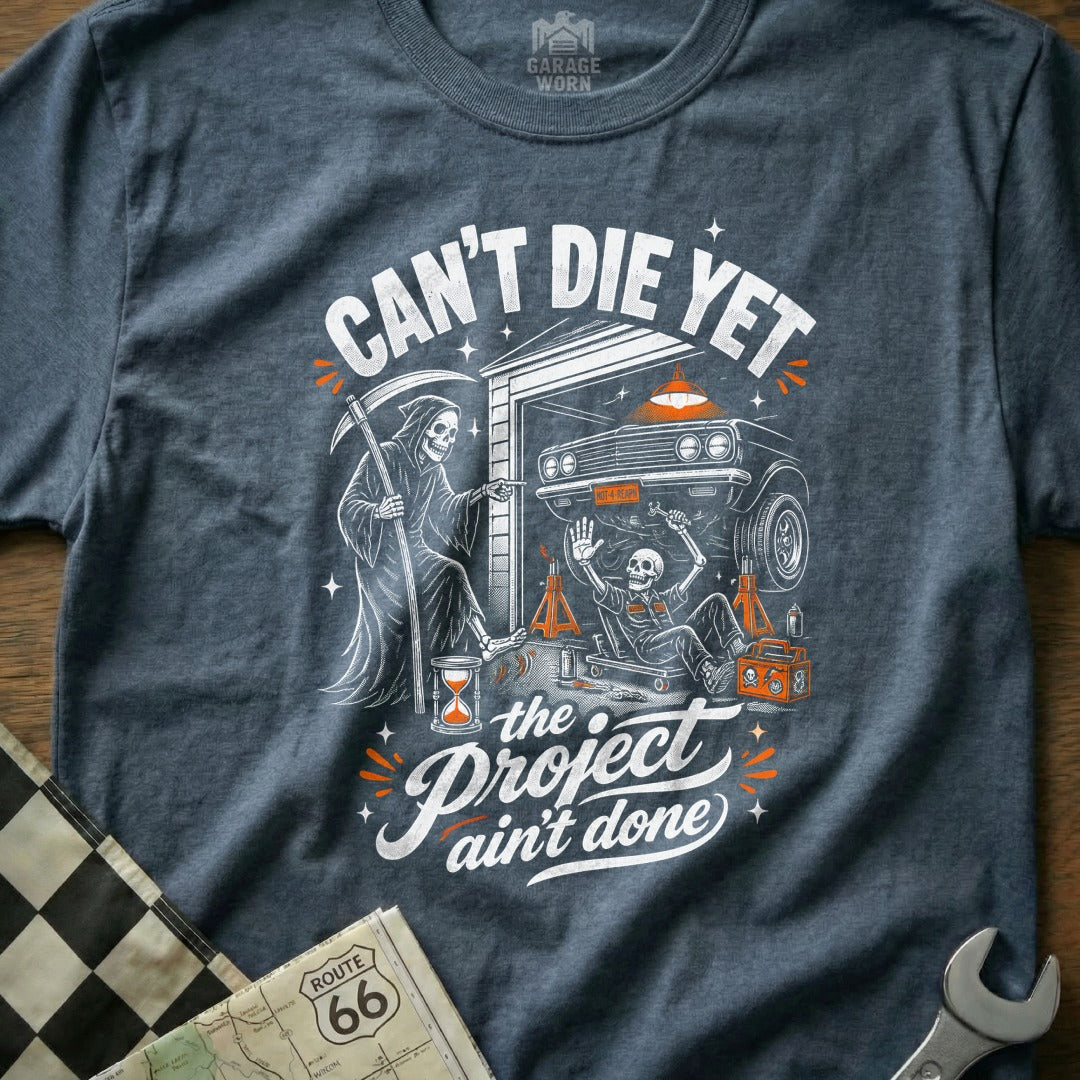 T-shirt with grim reaper, skeleton, car, and text "Can't Die Yet. The Project Ain't Done."
