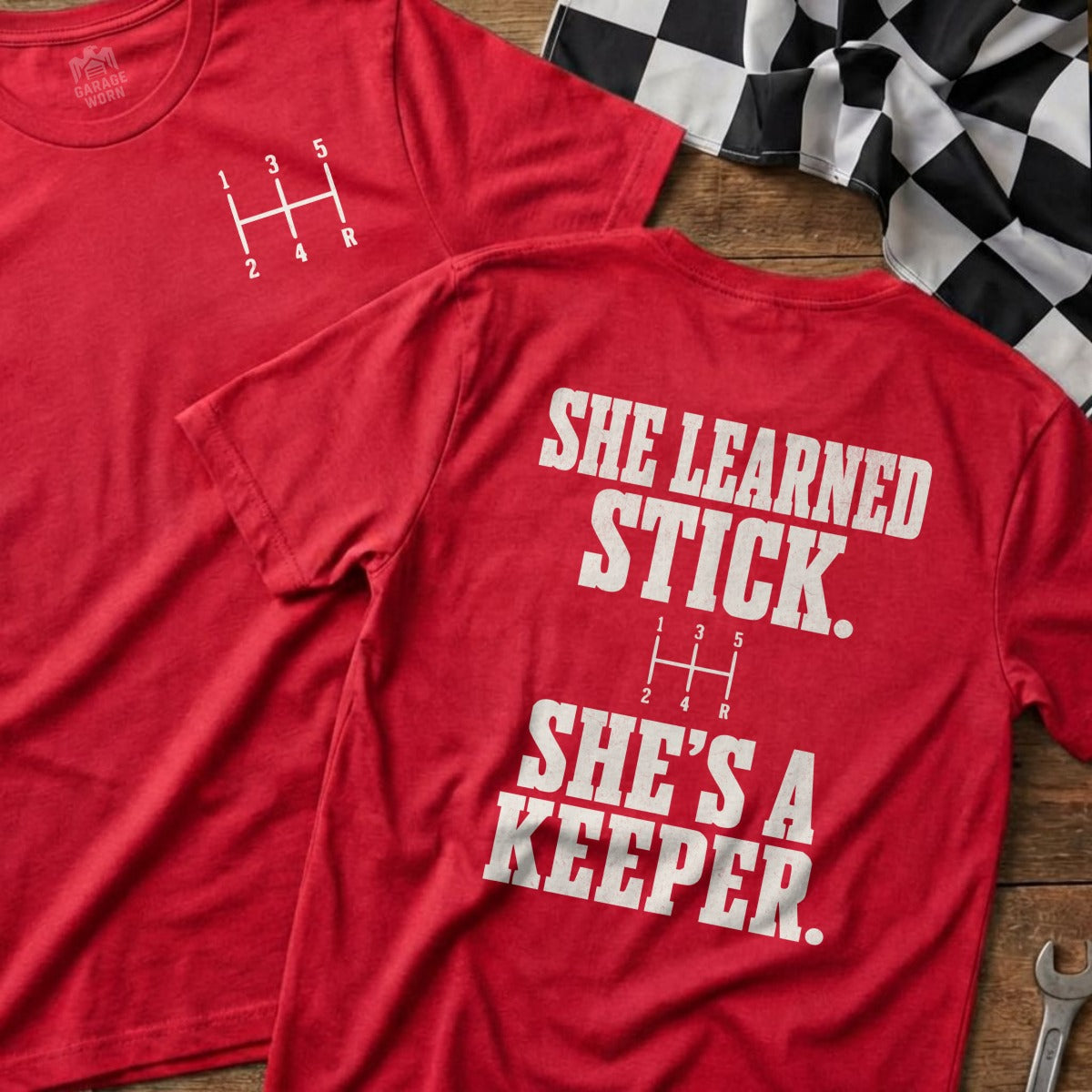 Red t-shirt with a manual gear shift pattern and "She learned stick. She's a keeper." text.