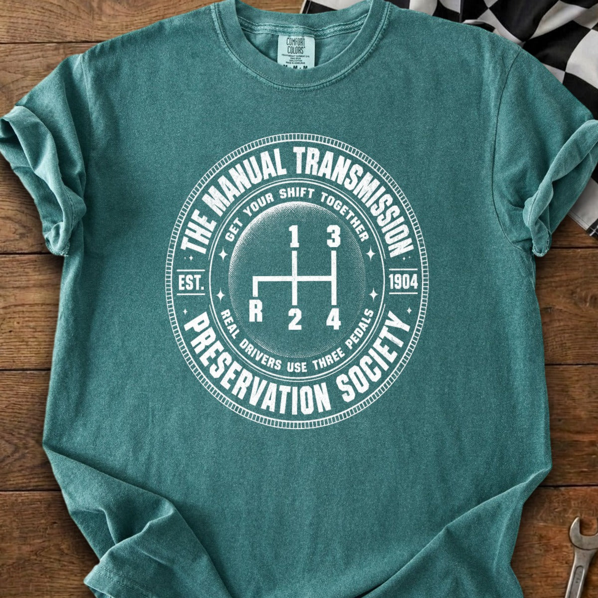 Teal t-shirt with "The Manual Transmission Preservation Society" and gear shift graphic.