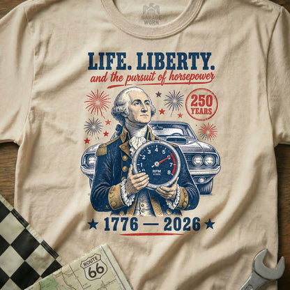 George Washington holds a speedometer with "LIFE. LIBERTY. and the pursuit of horsepower" and "1776-2026" text.