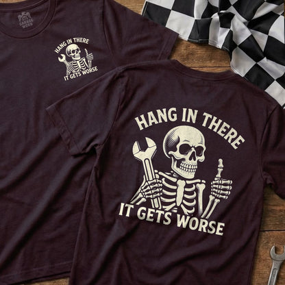 Maroon t-shirt with skeleton holding wrench and "Hang in there it gets worse" text.