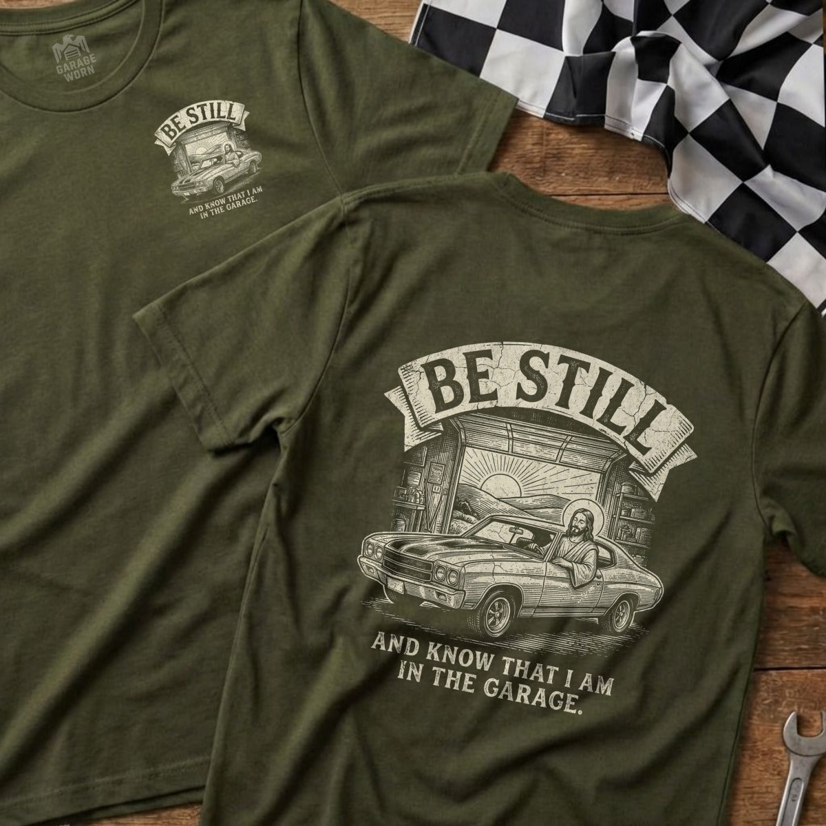 Olive green t-shirt with Jesus in a car and "Be Still" text.