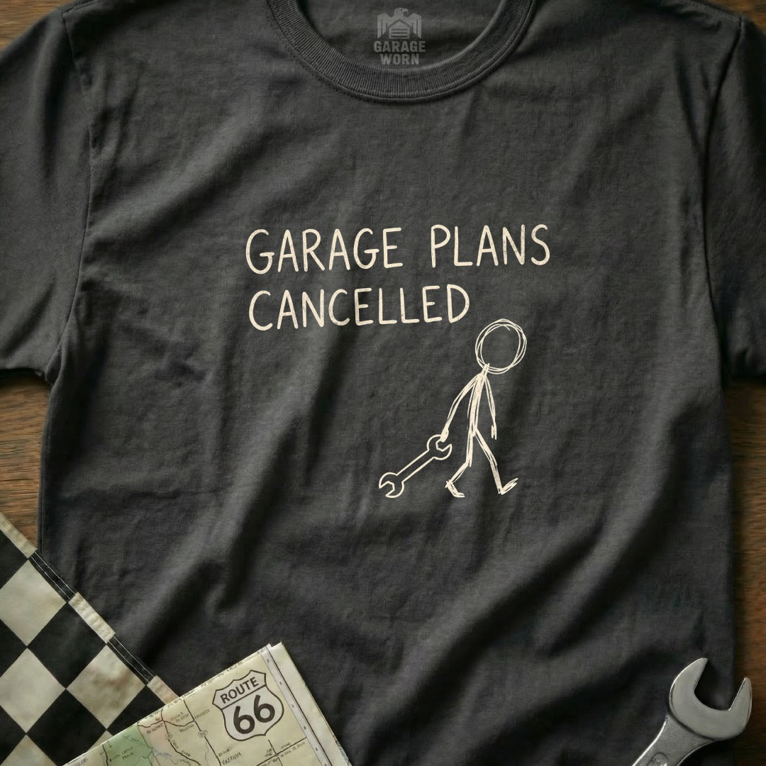 Dark t-shirt with "GARAGE PLANS CANCELLED" and a stick figure holding a wrench.