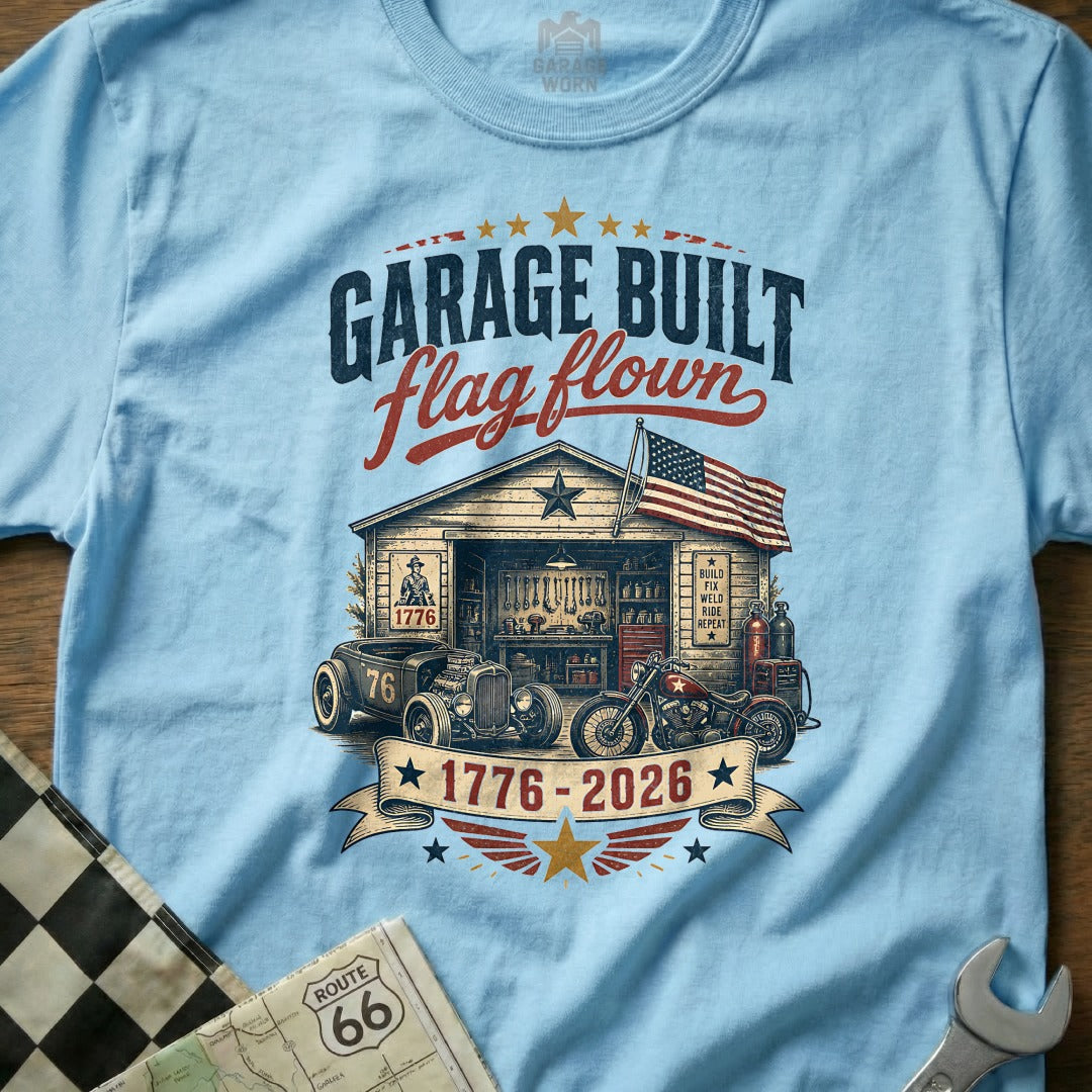T-shirt graphic with garage, hot rod, motorcycle, and American flag.