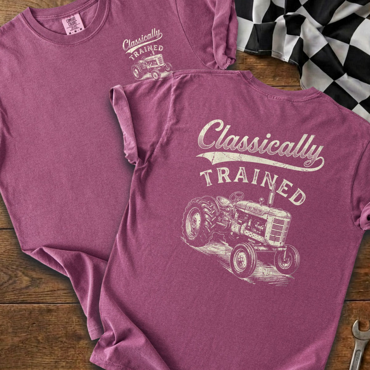 T-shirt with "Classically TRAINED" text and vintage tractor graphic on plum-colored fabric.