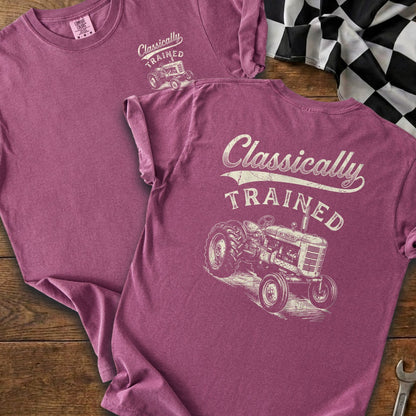 T-shirt with "Classically TRAINED" text and vintage tractor graphic on plum-colored fabric.
