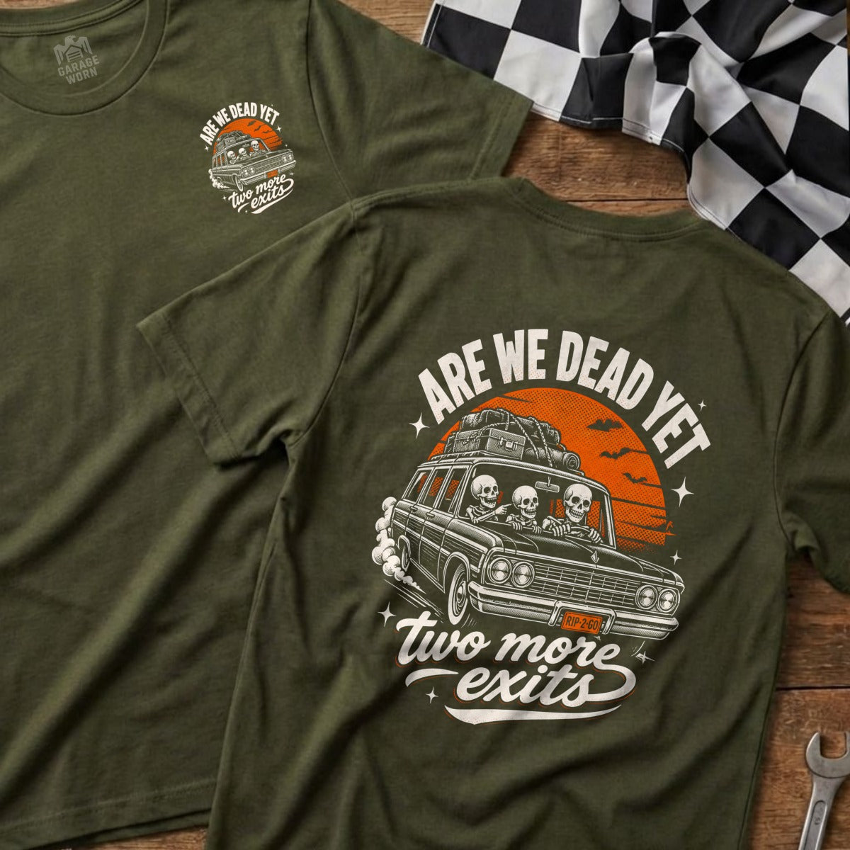 T-shirt with graphic of skeletons in a car, "ARE WE DEAD YET" and "two more exits".