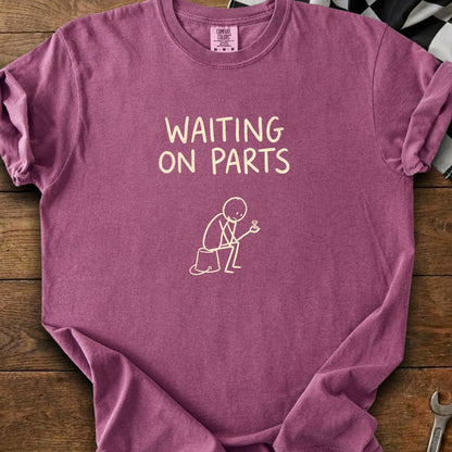 Mauve t-shirt with "WAITING ON PARTS" text and a stick figure holding a screw.