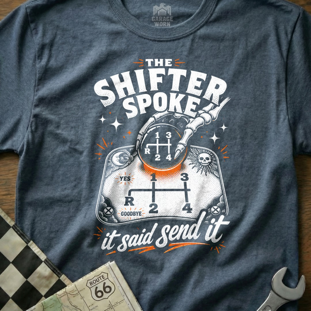 Dark gray t-shirt with graphic: skeleton hand on gear shift, text "The Shifter Spoke It Said Send It".