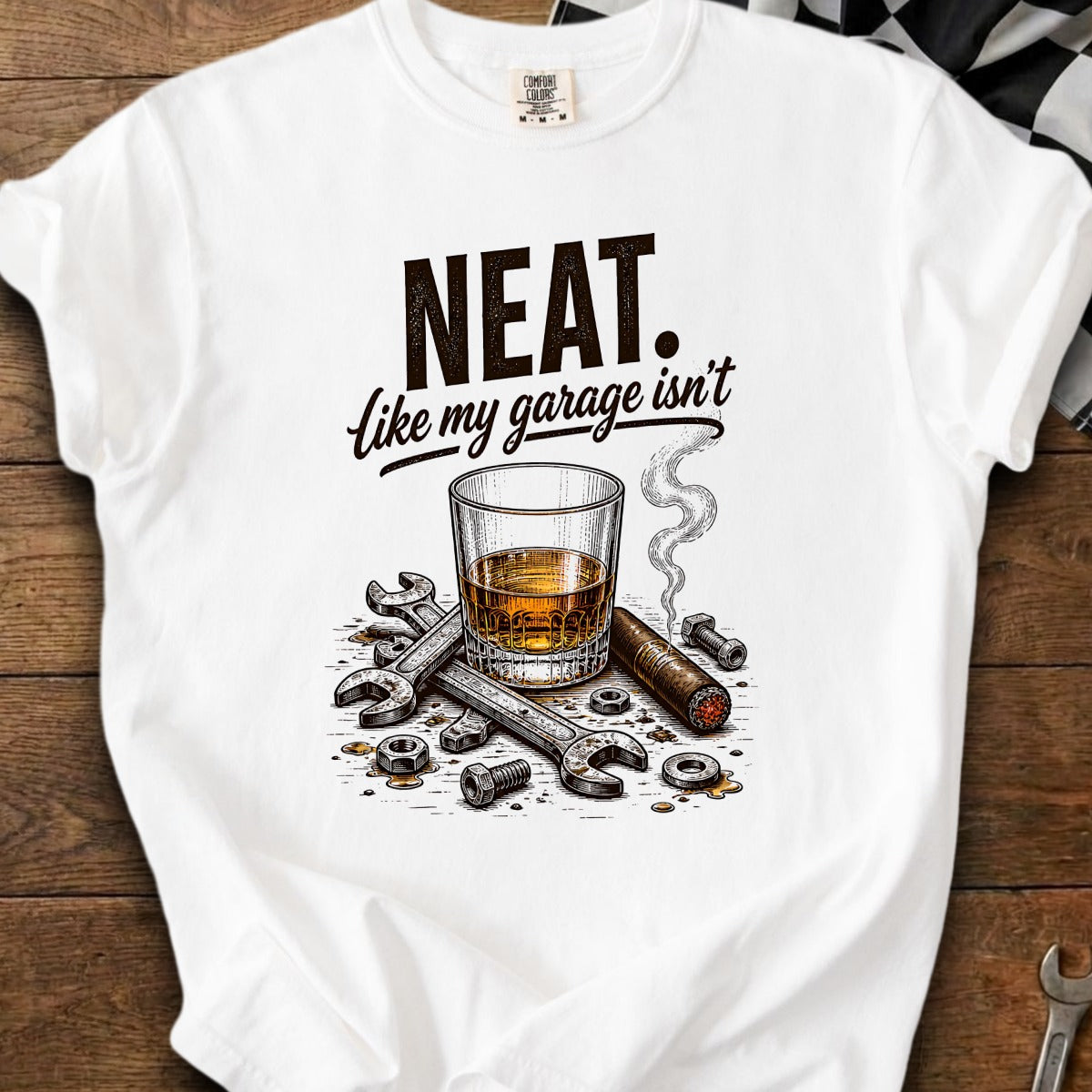 T-shirt graphic: "NEAT. Like my garage isn't" with whiskey, cigar, and tools.