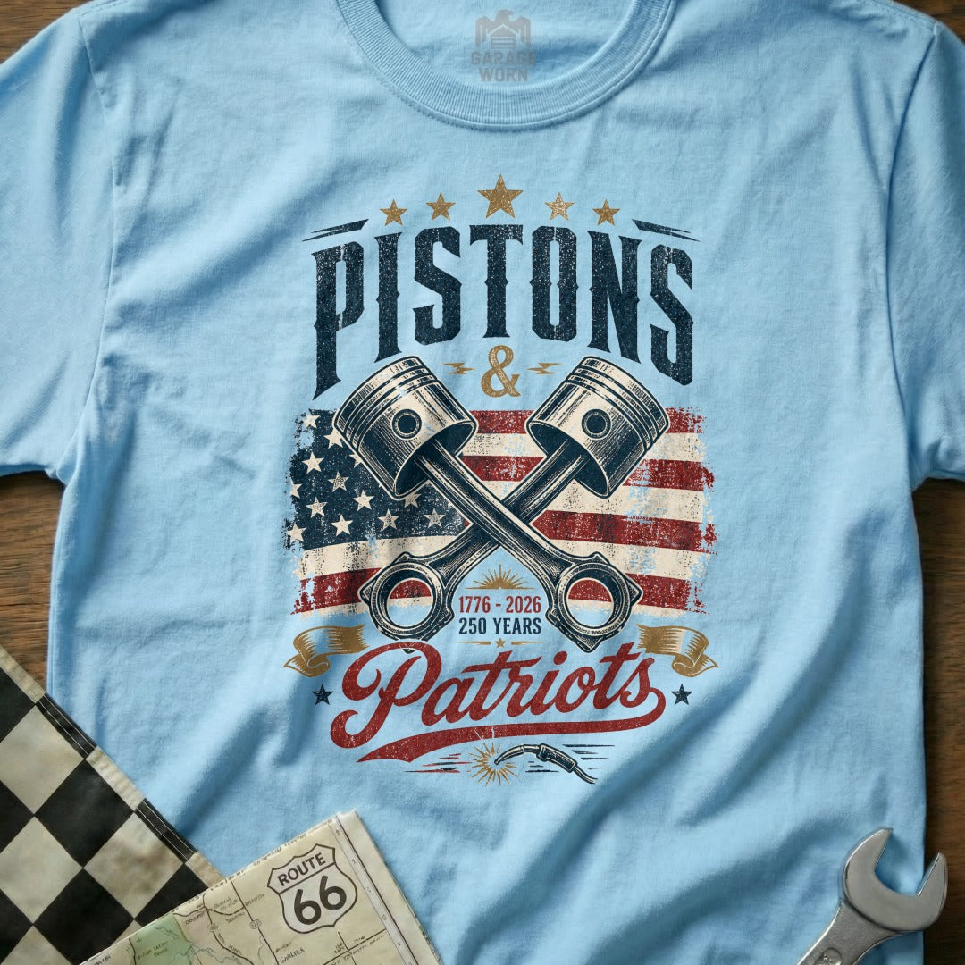 Light blue t-shirt with "Pistons & Patriots" and crossed pistons over US flag.
